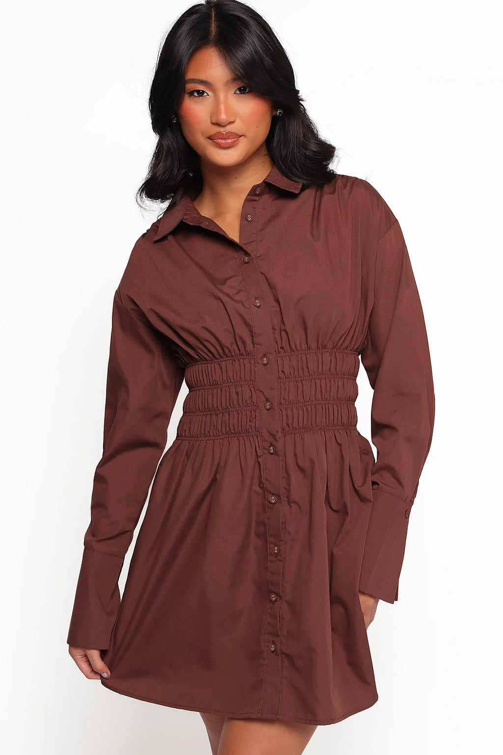 Buttoned long sleeves and elasticised shirred waist on a brown mini dress