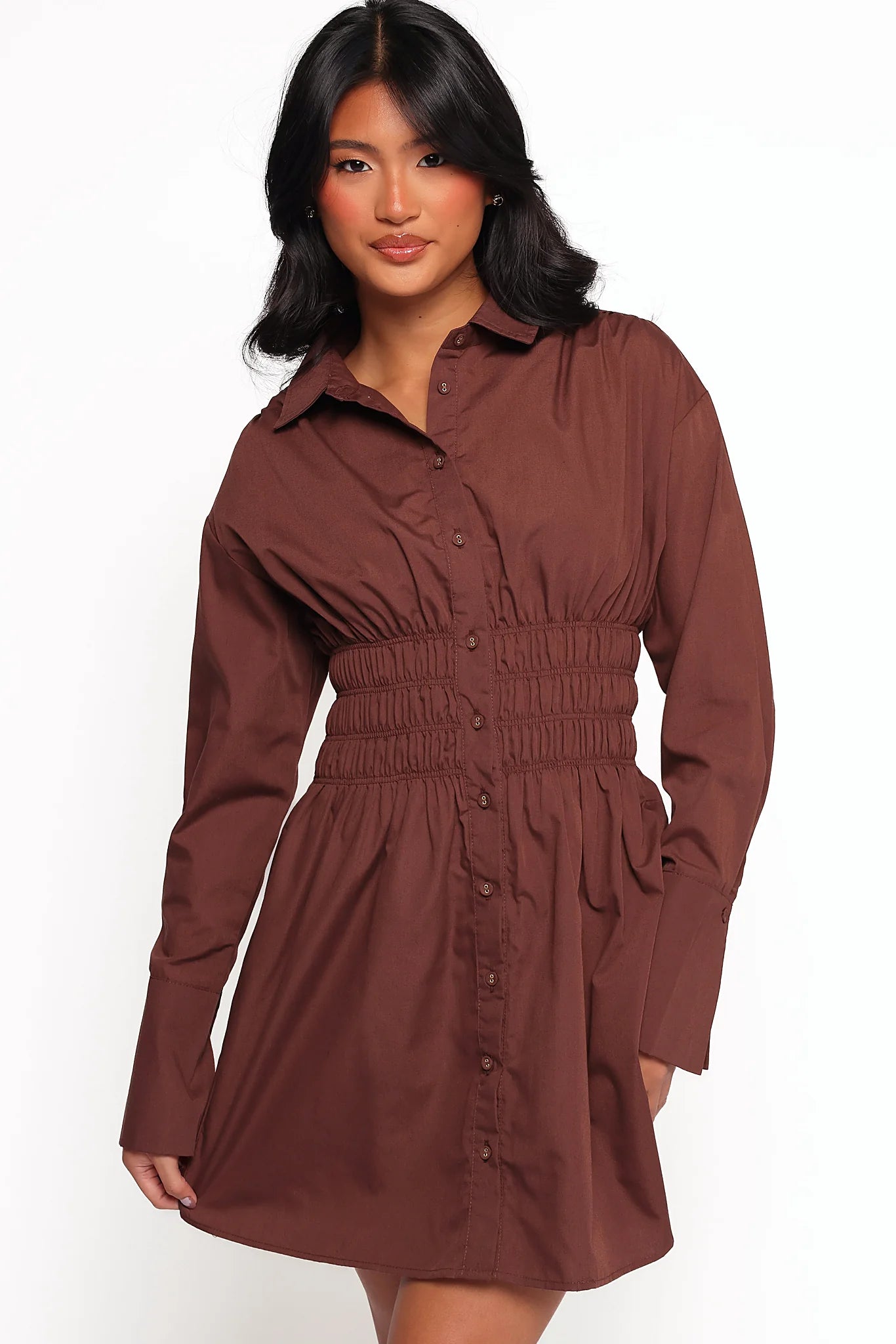 Buttoned long sleeves and elasticised shirred waist on a brown mini dress